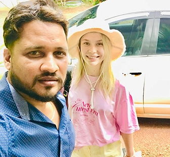 Nishan welcoming a traveller beside their vehicle